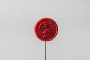 Odznak kruhový červený s nápisom KSS kosákom a kladivom
